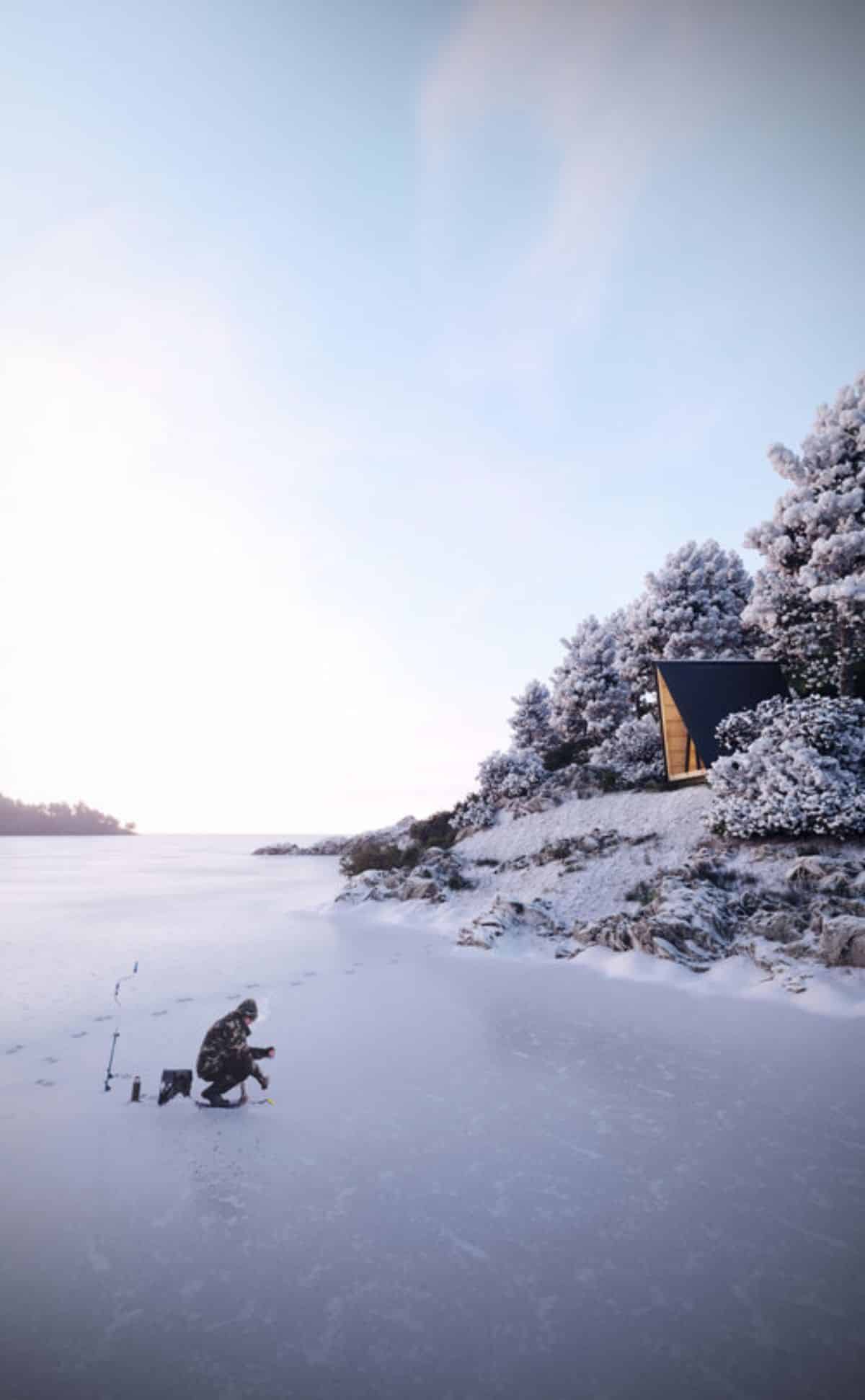 a-frame on edge of beach with frozen lake