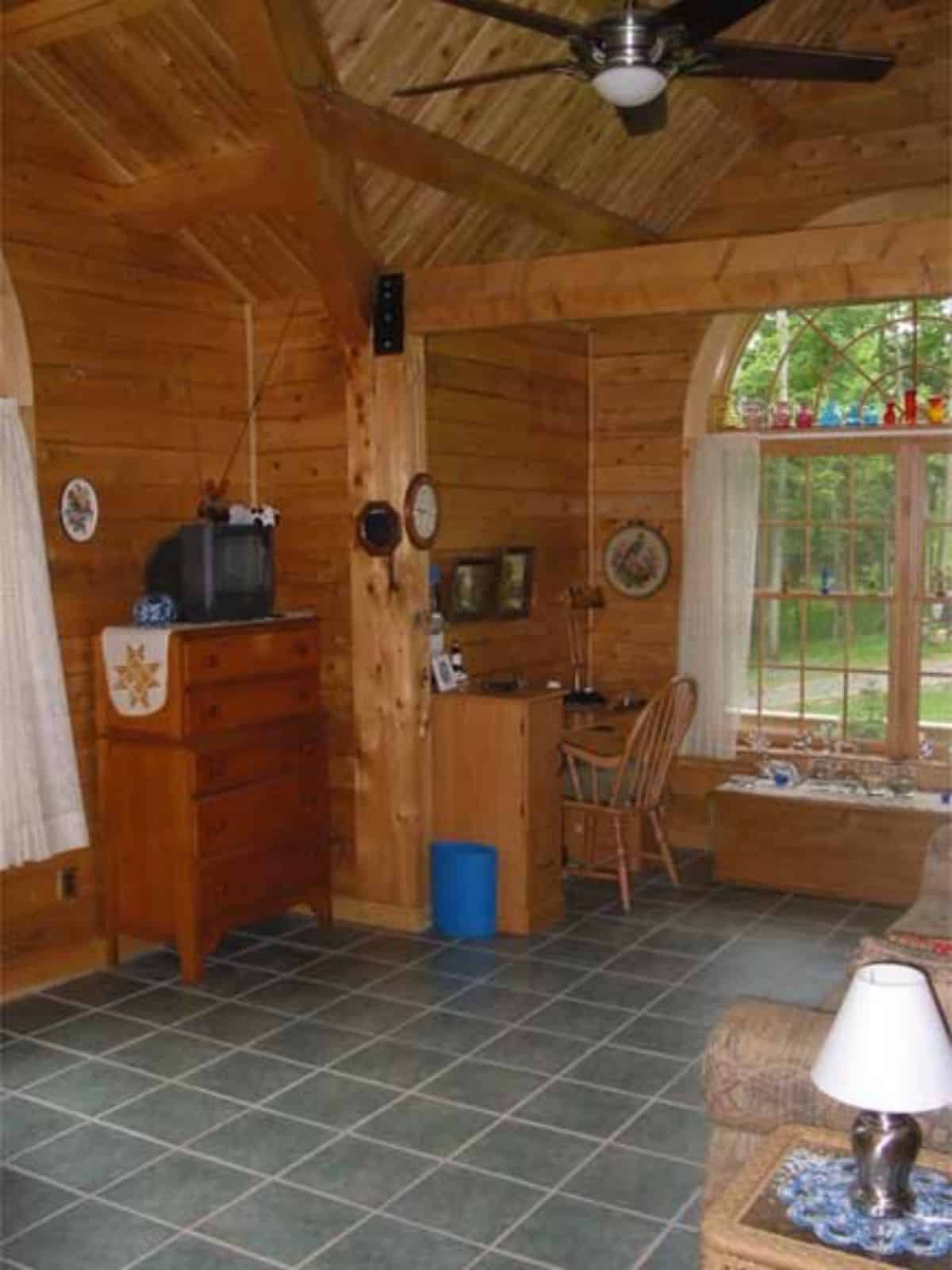 dining nook outside kitchen inside log cabin with blue tile floor