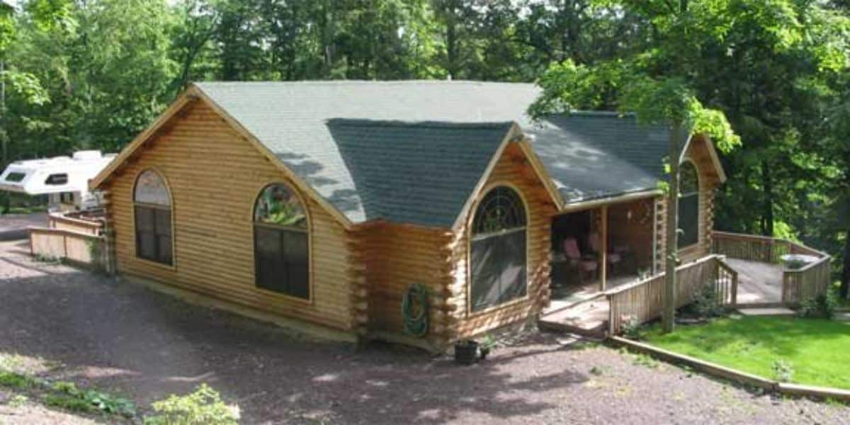 side of log cabin with sunroom on front