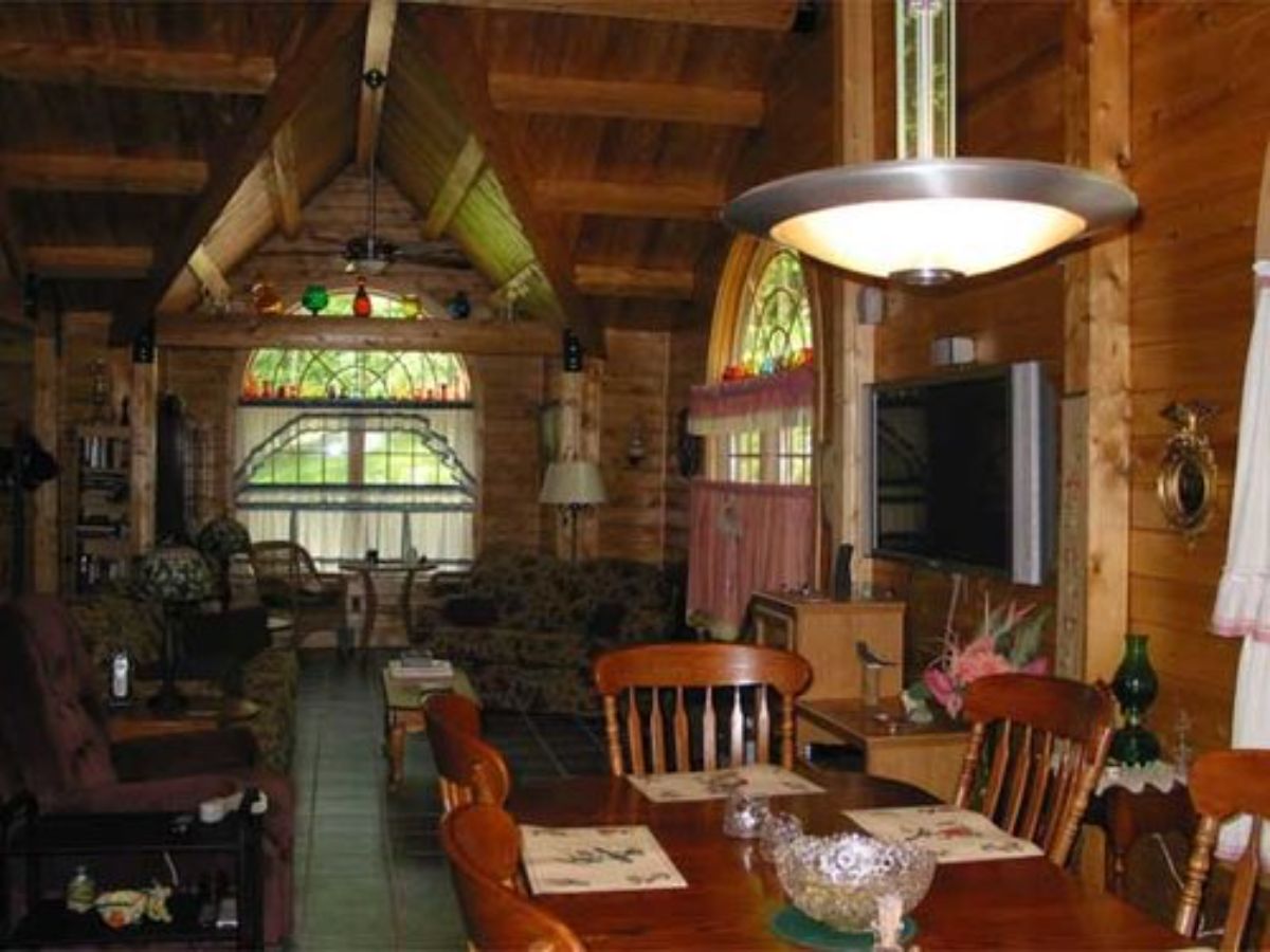 view across wood dining table to living area of cabin