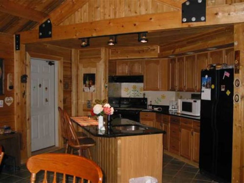wood cabinets and white and black appliances in cabin kitchen