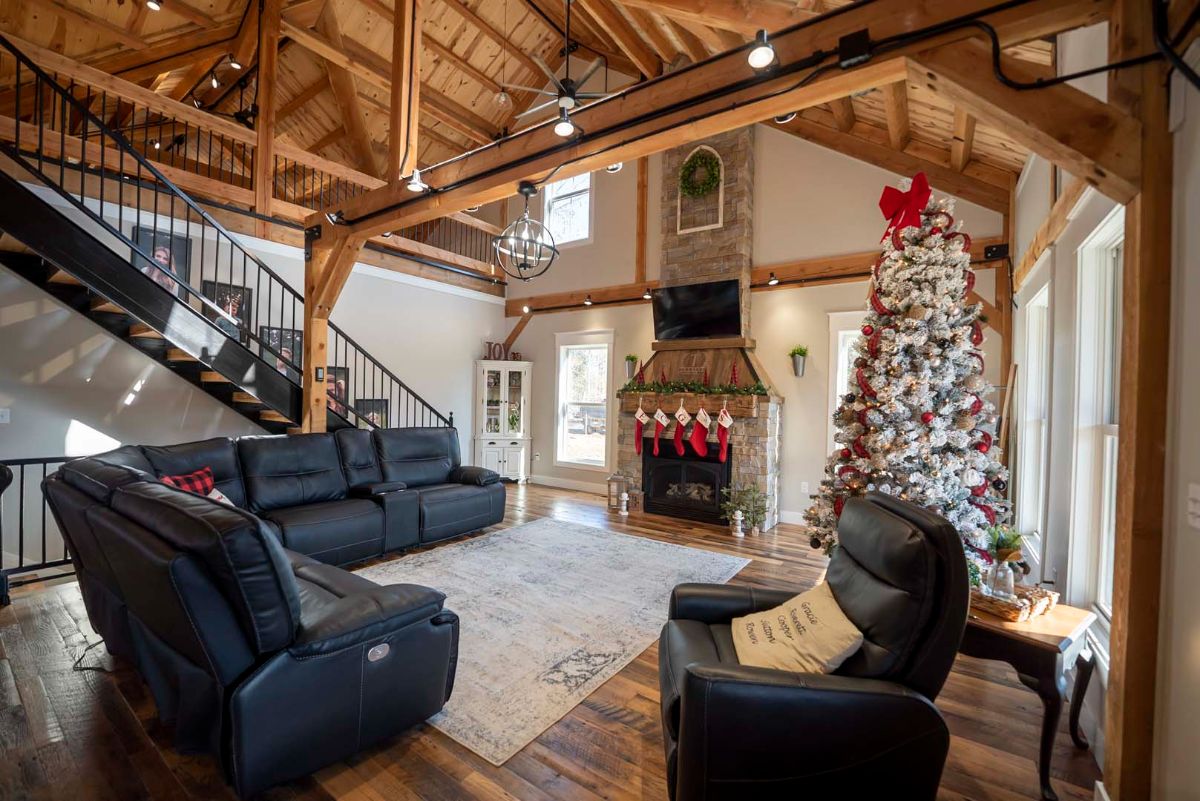 fireplace on right wall with christmas tree beside wall and black recliner