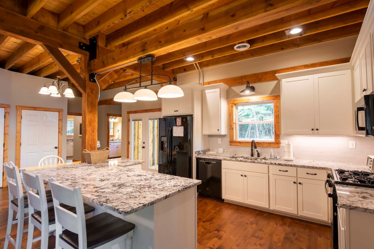 view into kitchen with black appliances and white cabinets