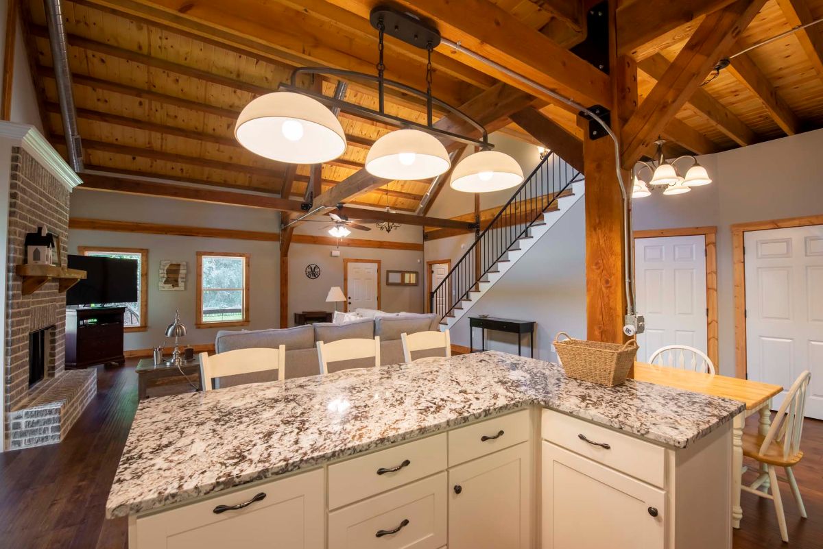 gray and white marbled counter under large trio of lights in kitchen