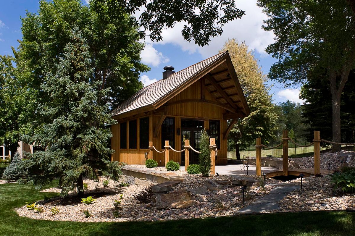 log cabin with patio and trees in background