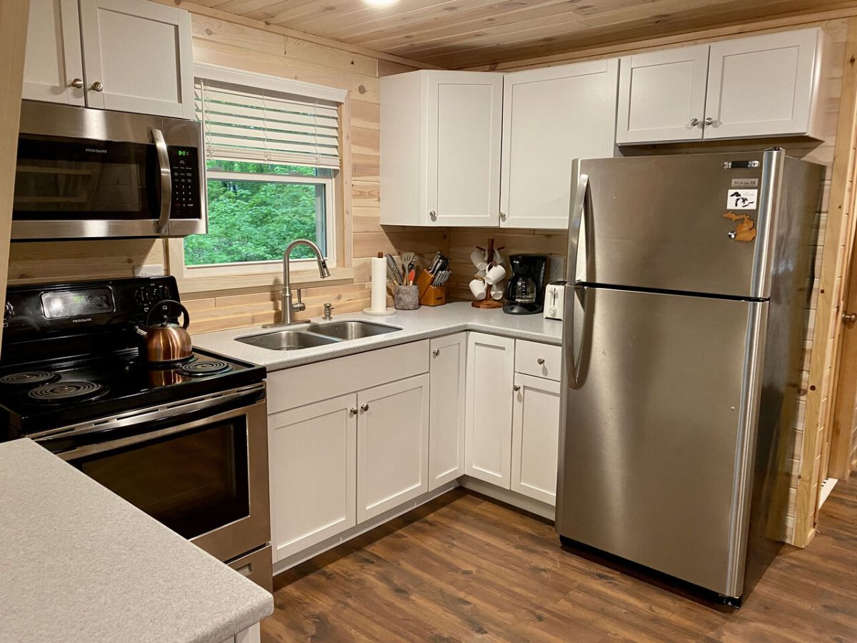 white cabinets with stainless steel appliances in kitchen of a-frame