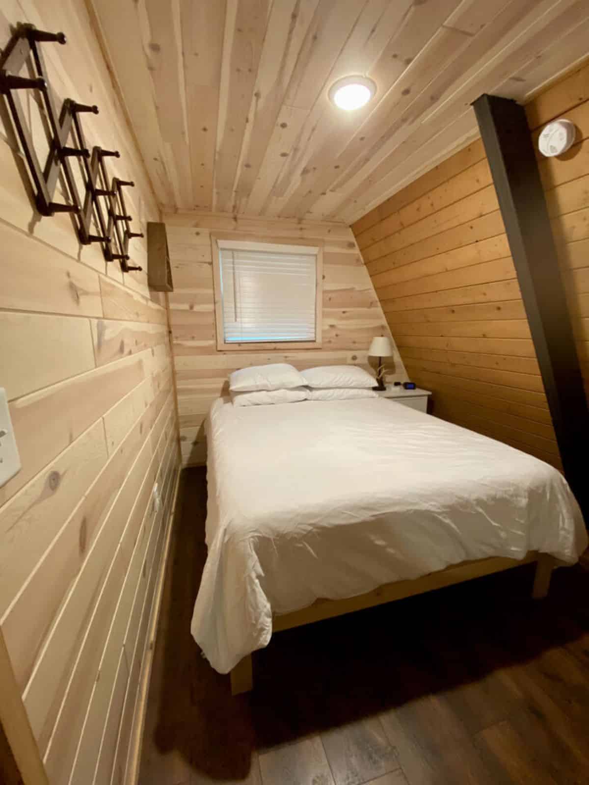 bed with white linens in main floor a-frame bedroom