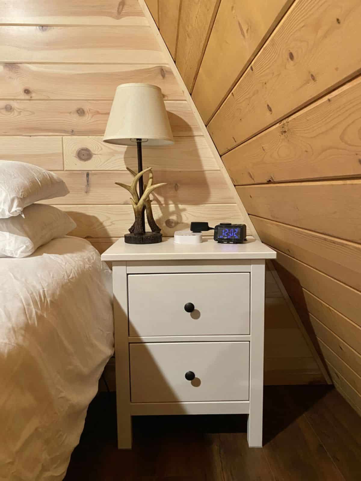 white night stand beside bed with white linens