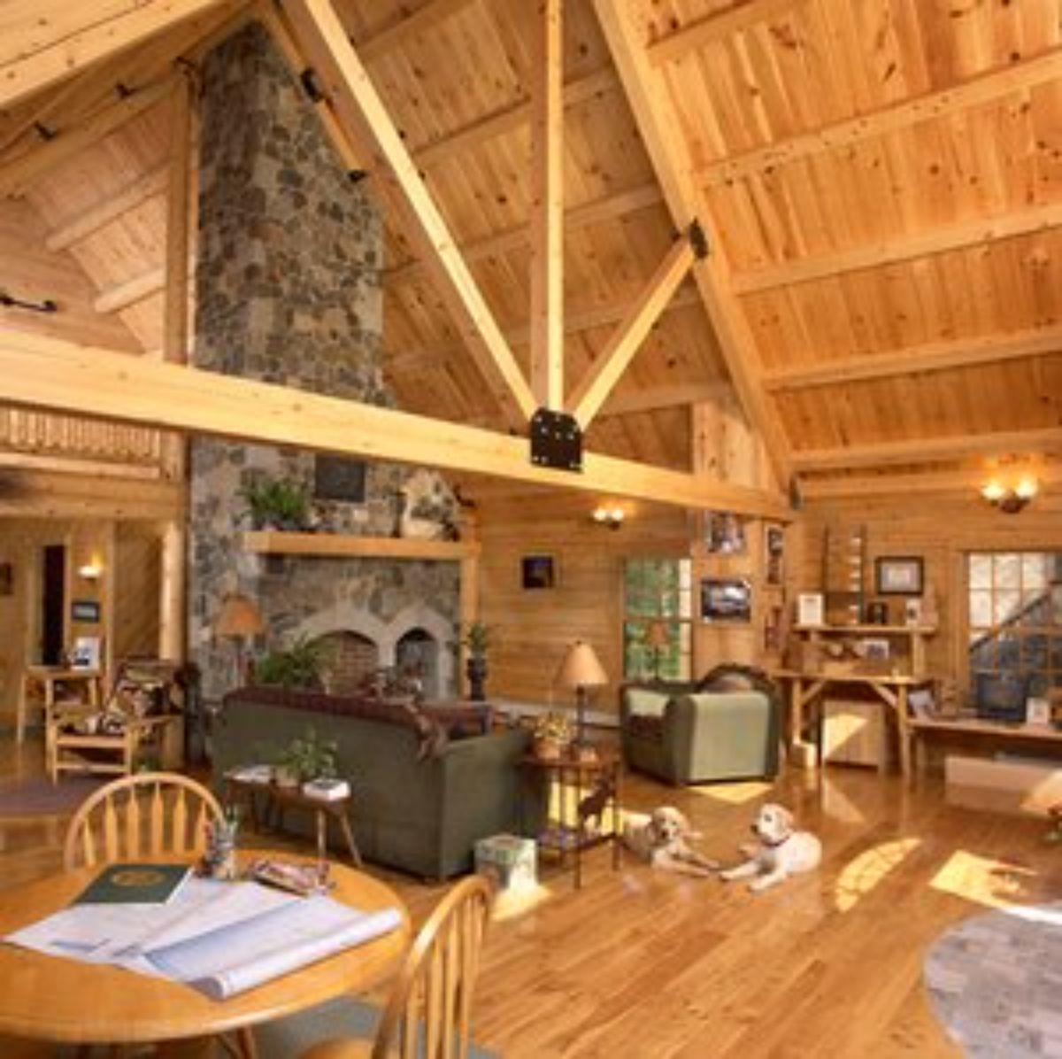 stone fireplace against wall with dining table in foreground inside cabin