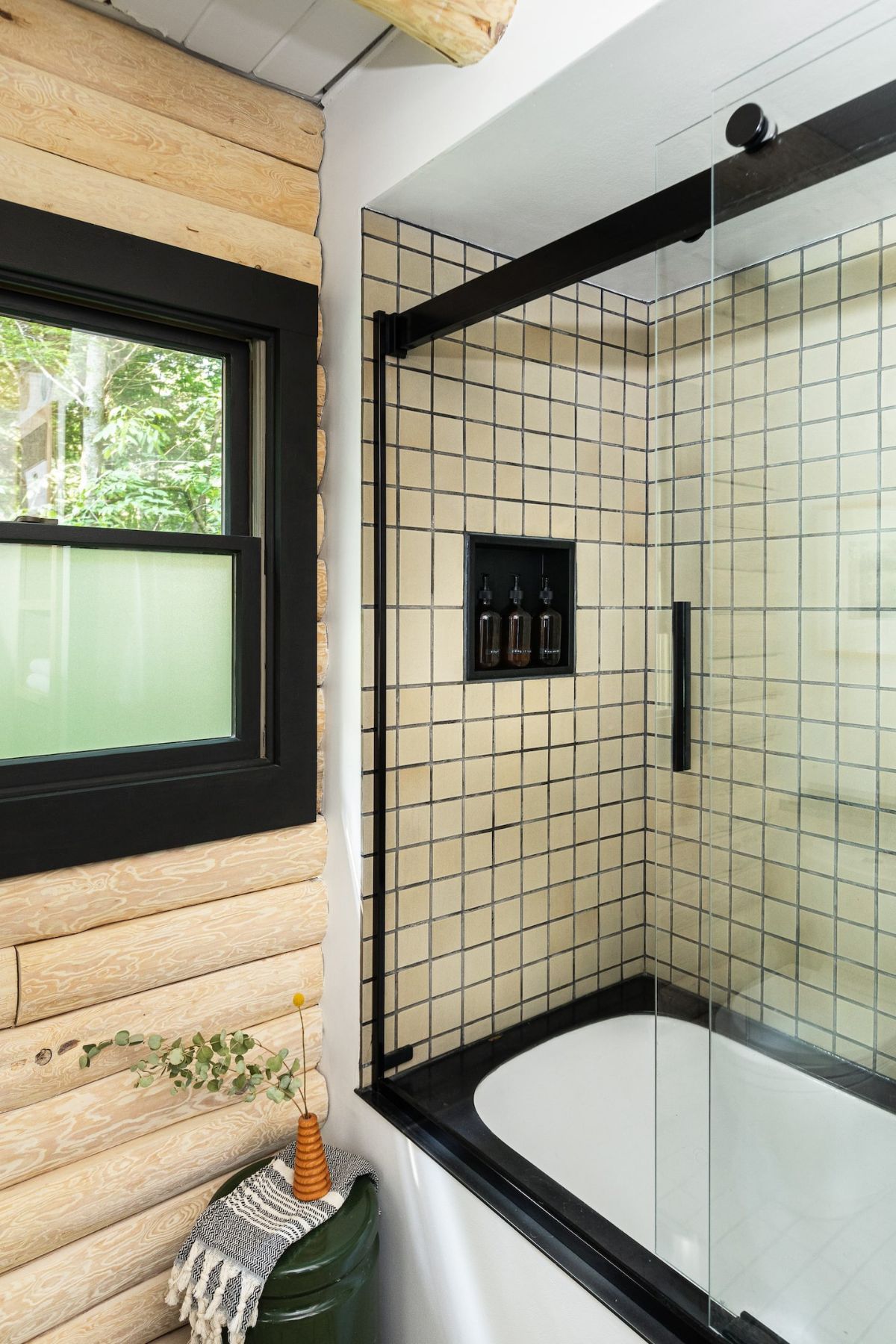 corner glass door shower with black and white tile