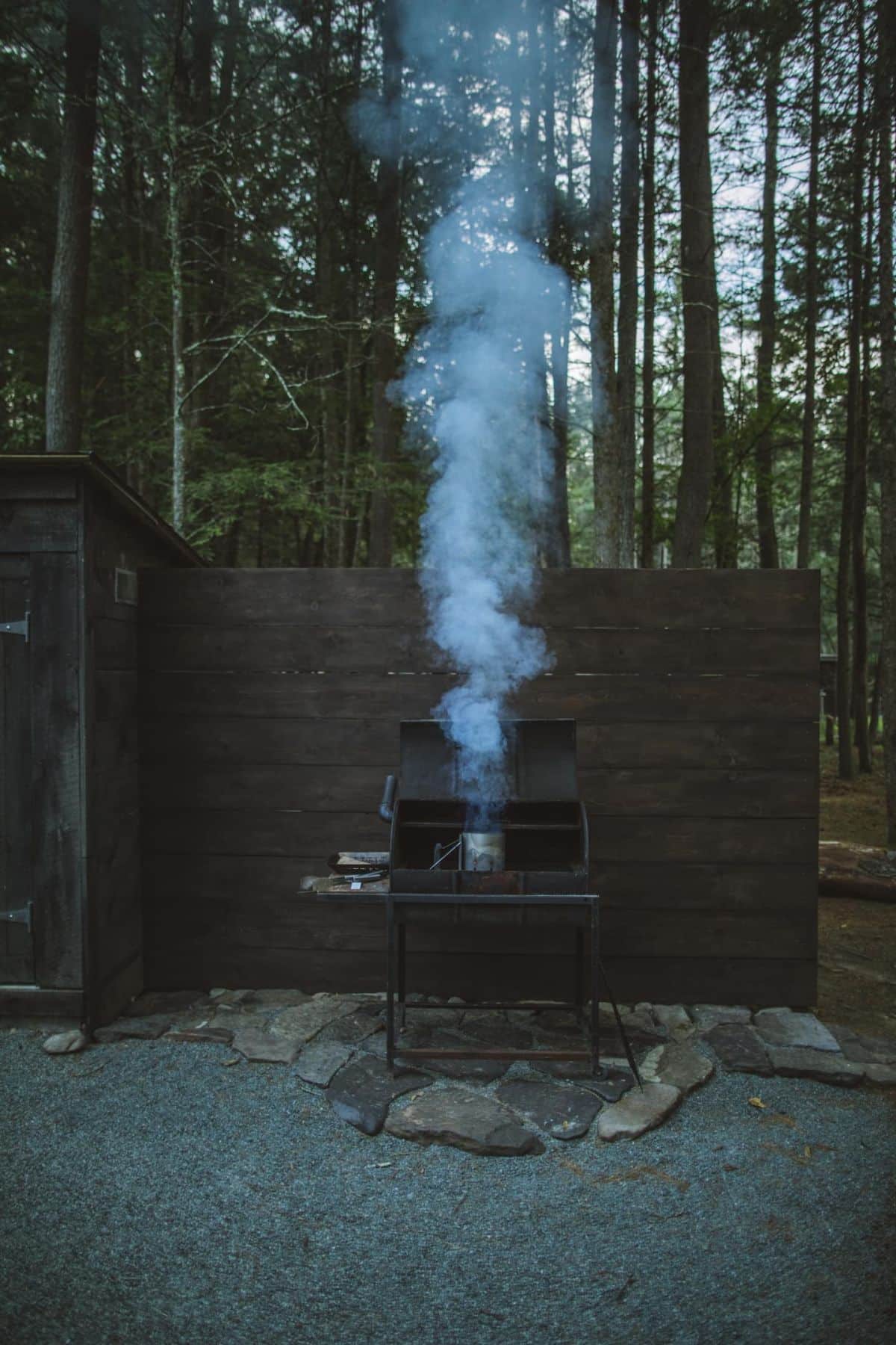grill against wood wall with smoke