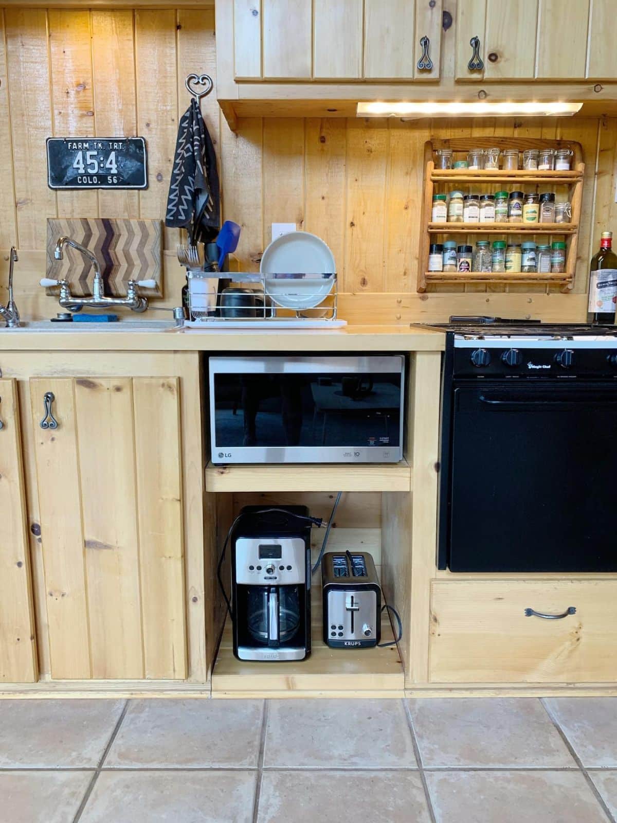 small stove and microwave set into light wood cabinets in kitchen