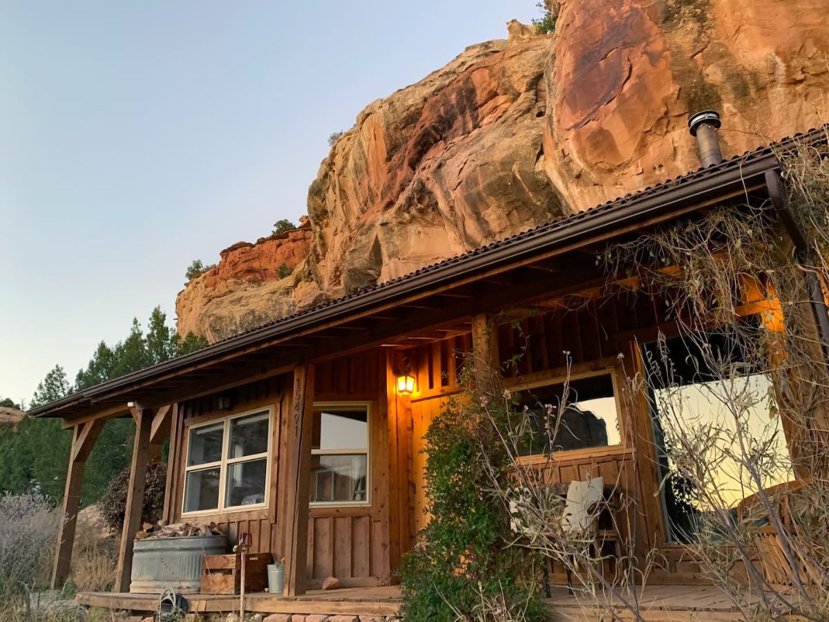 cabin set against rock hill with small covered porch