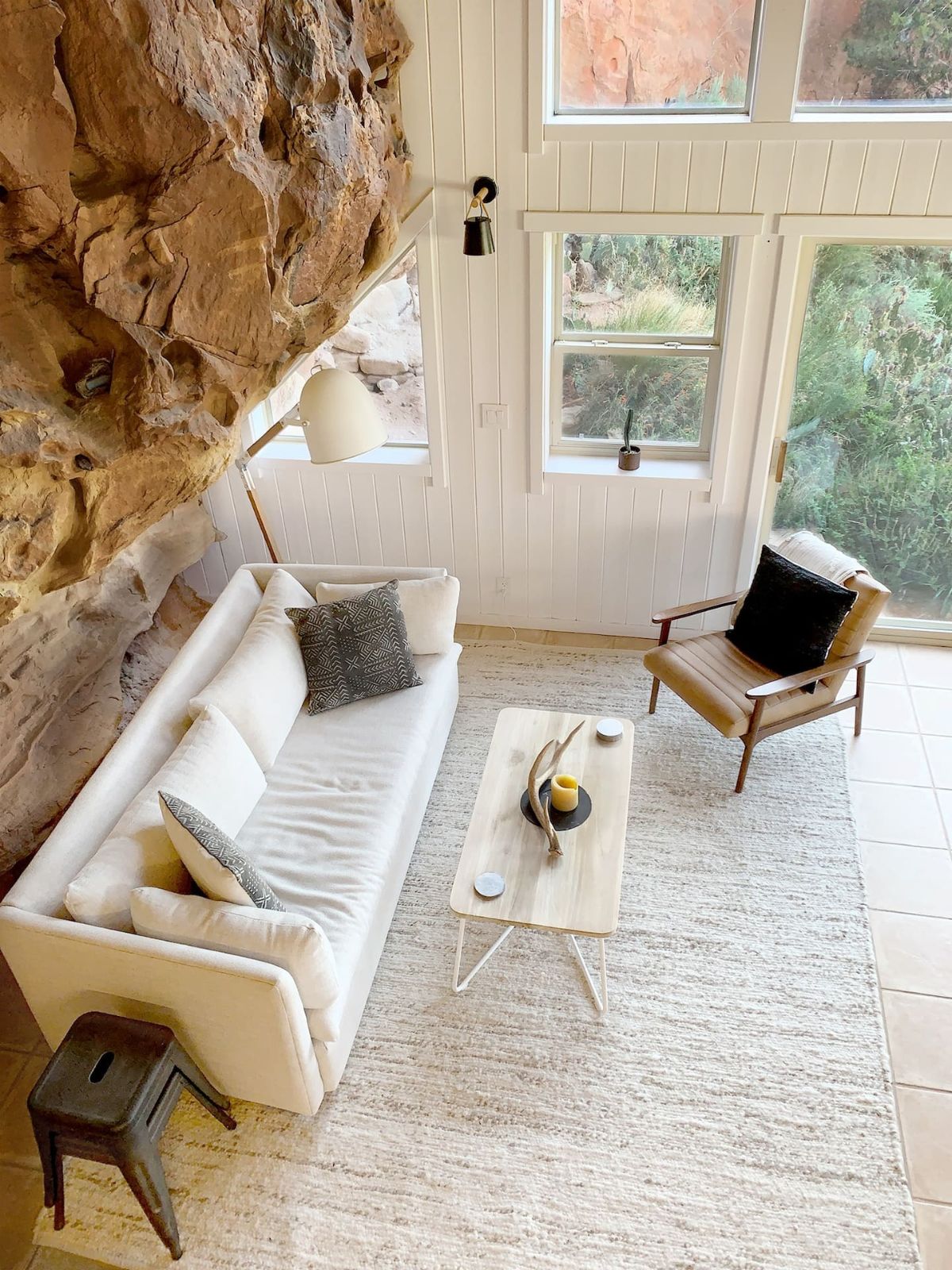 white sofa against rock wall inside cabin