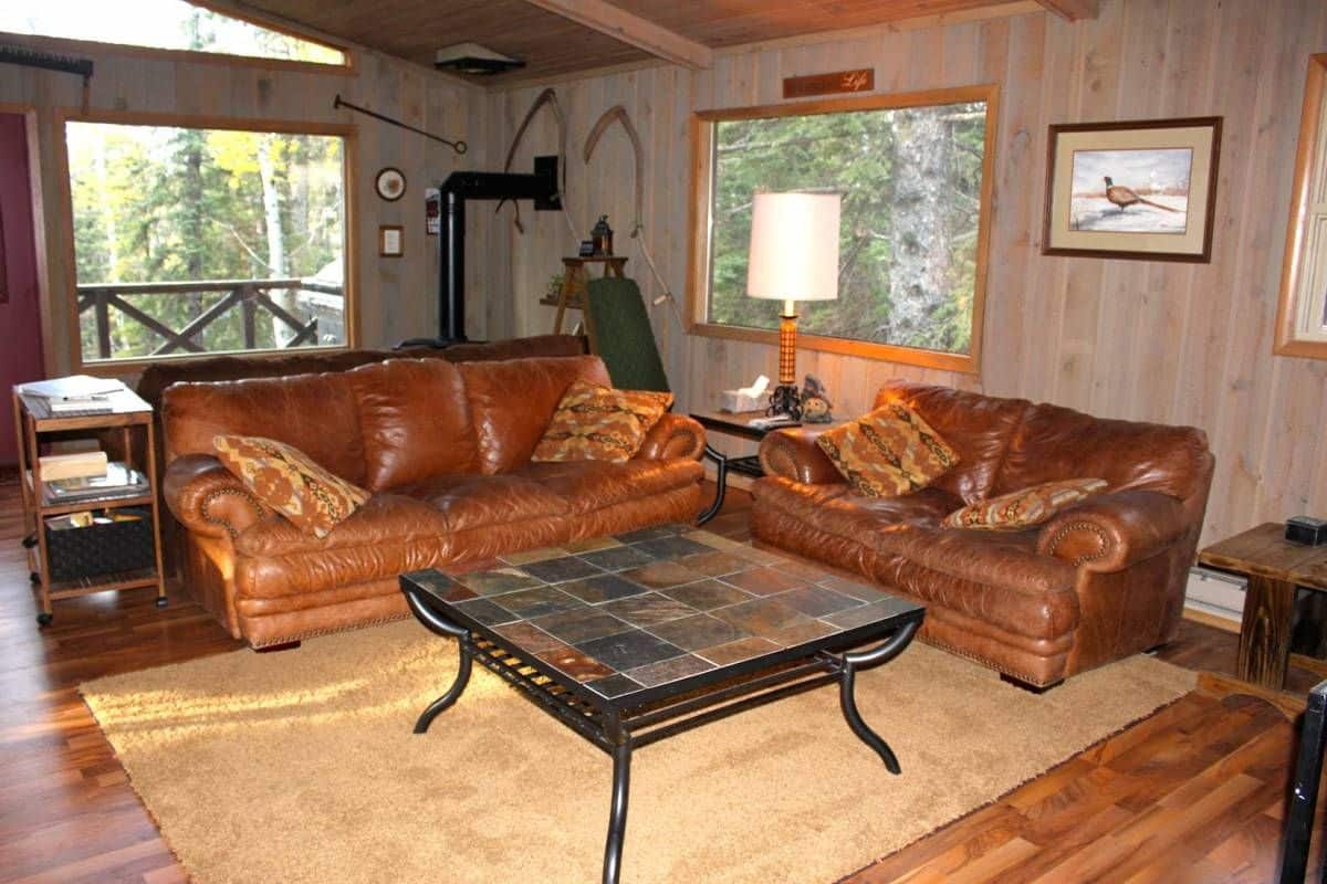 square coffee table with slate top in front of brown sofas