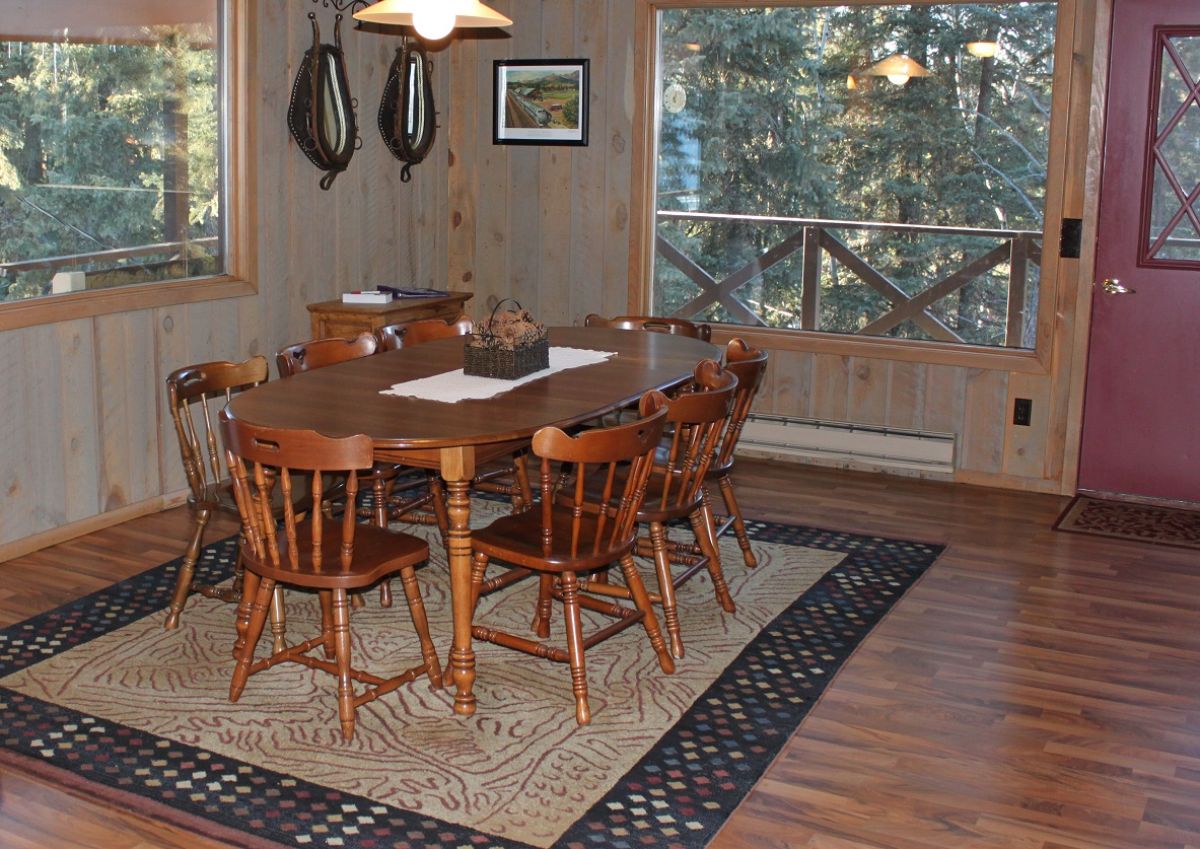 wood oval dining table on top of cream and blue rug