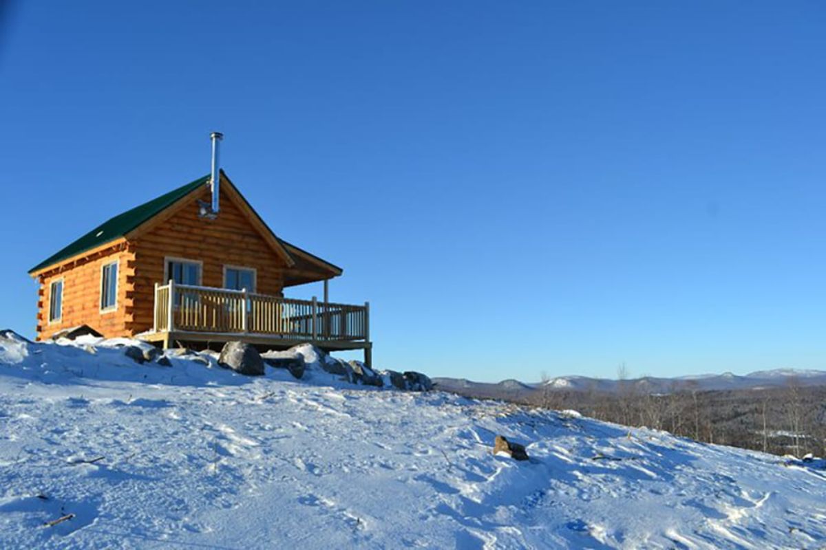 small cabin on hill of snow