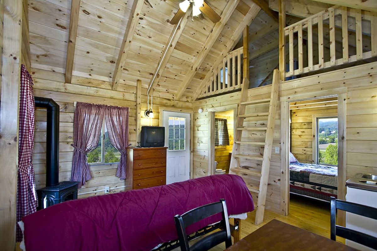 living area inside cabin with futon sofa that has purple blanket over back