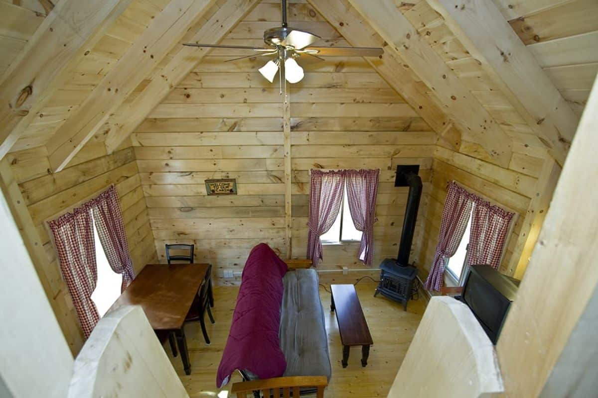 view from loft landing down into living area with futon sofa in center of space