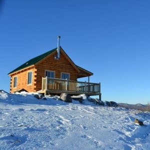small cabin on hill of snow