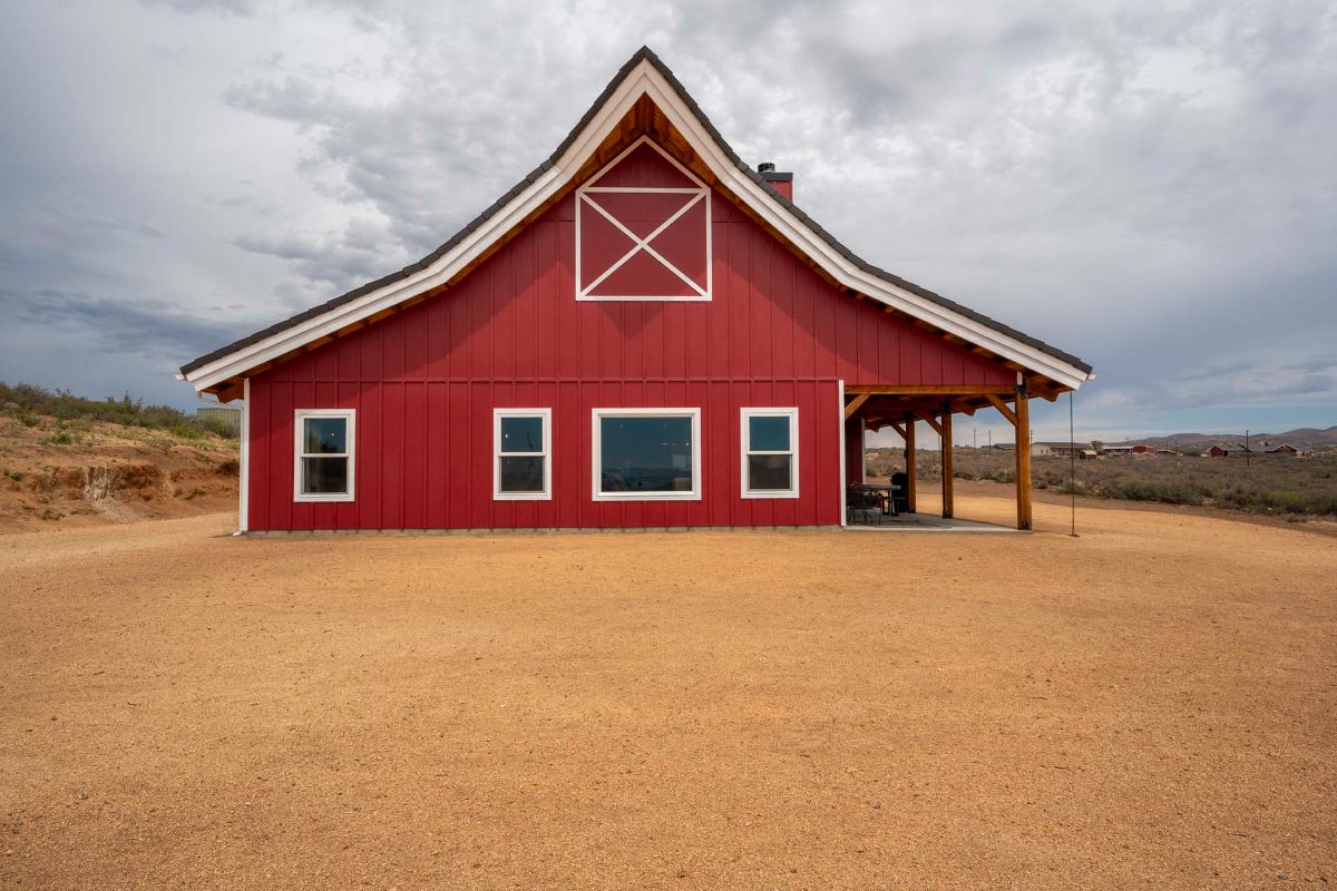 side of barn home with white shutters on windows