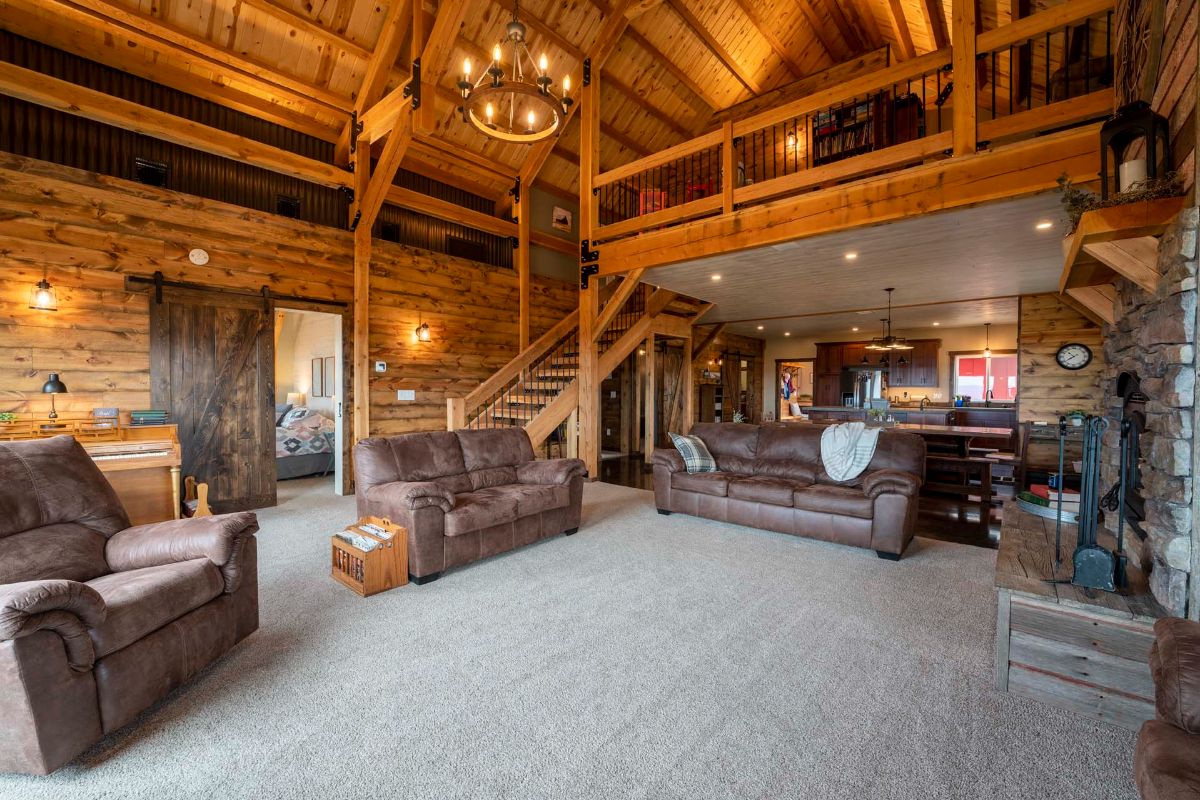 brown sofa and loveseat in center of cabin living room with tall ceiling