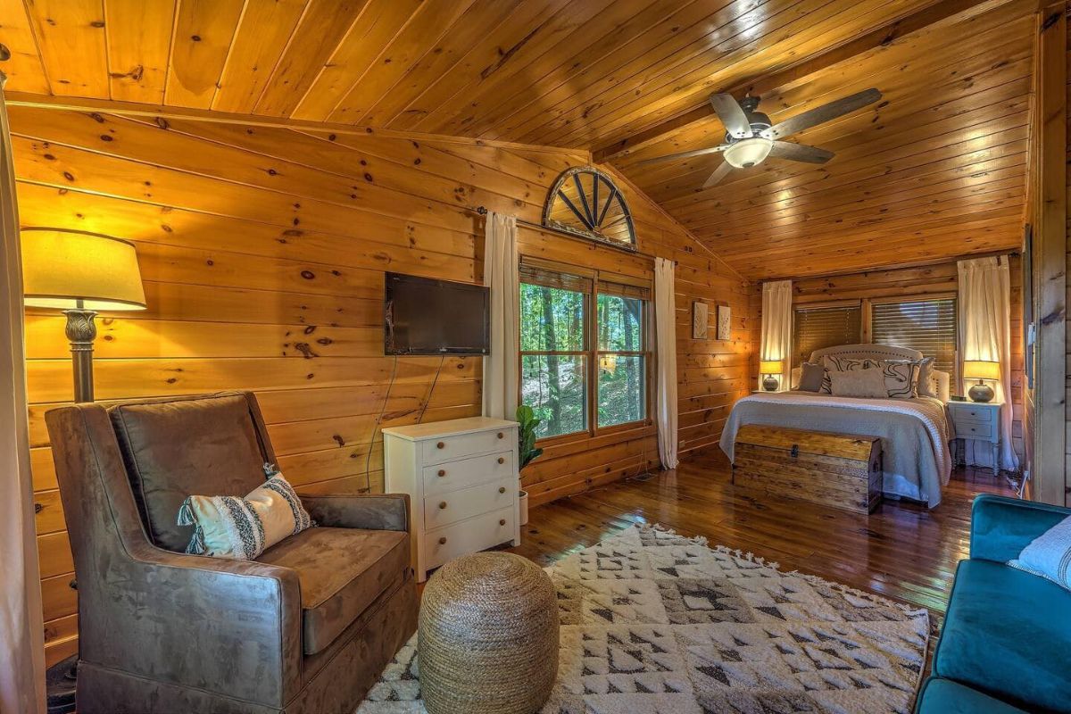 bed against wall with windows to left and chair in foreground