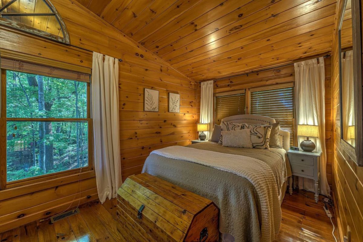 wood trunk at end of bed with blue and white linens