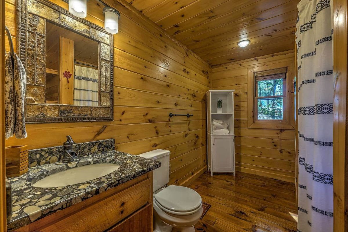 wood walls in bathroom with granite counter and open wall space