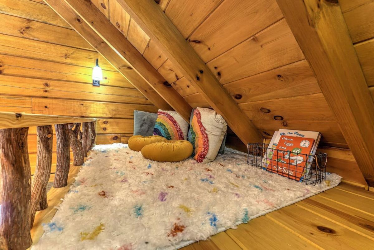 white and rainbow colored rug on loft floor with rainbow pillows on side