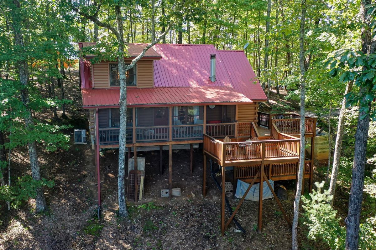 porches on back of cabin with stairs to hill leading down mountain