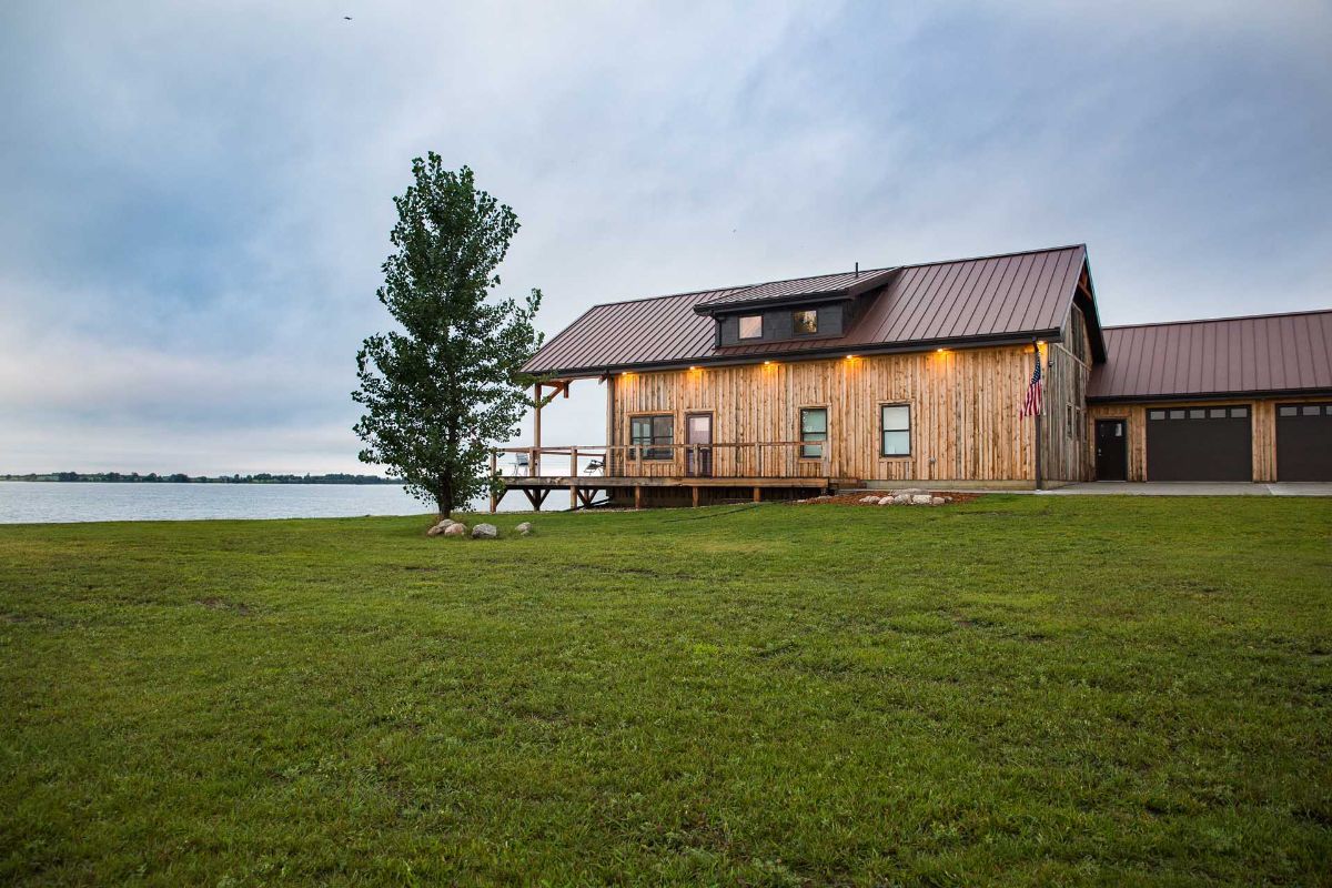 tree next to porch on side of cabin overlooking water