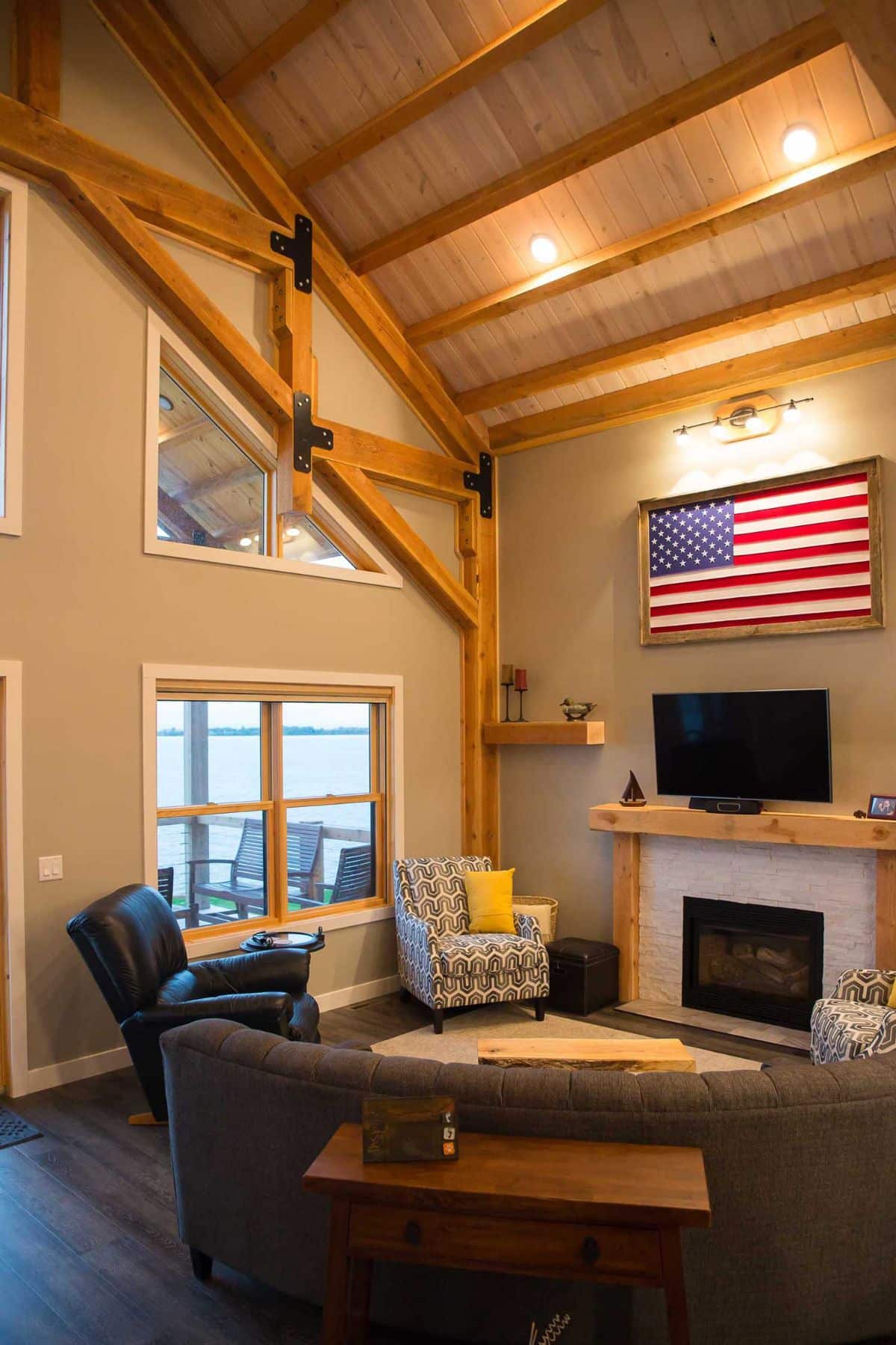 fireplace against wall with windows overlooking water on left