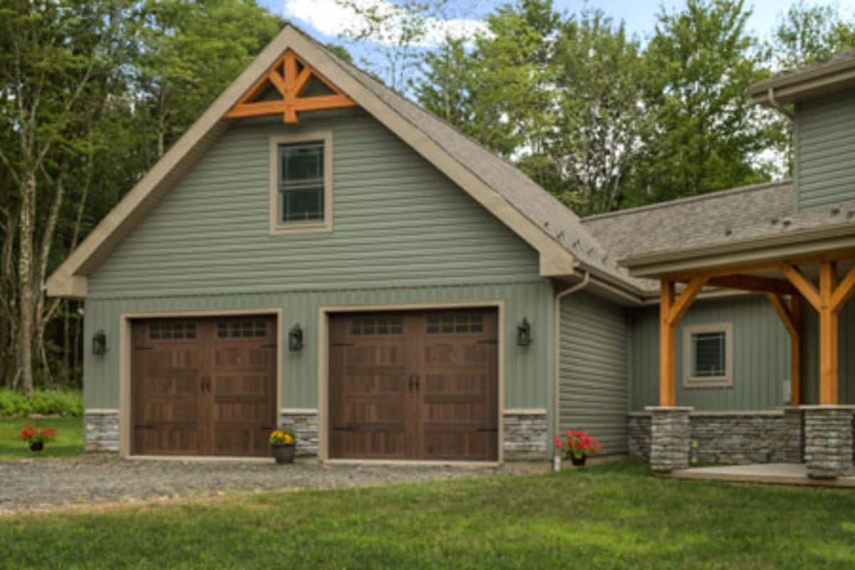 green siding with brown doors on garage