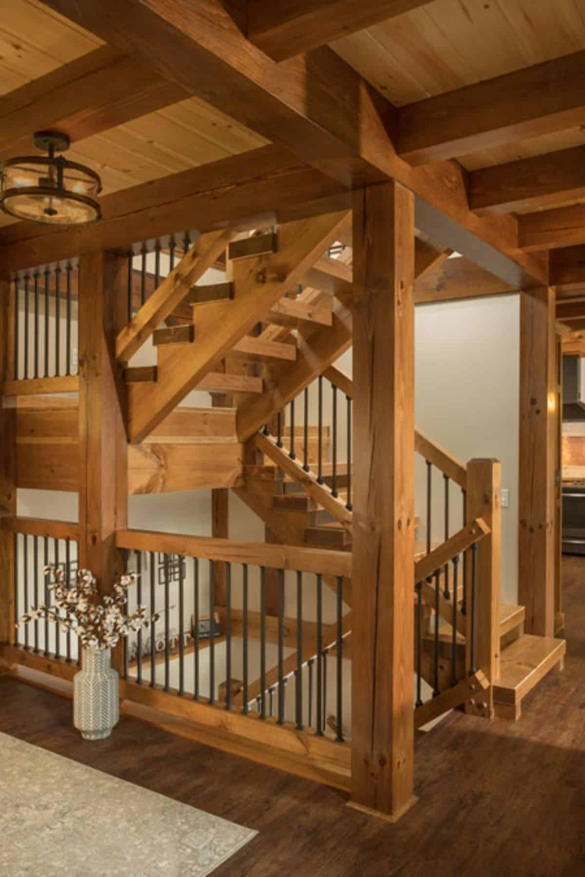 wooden stairs in corner leading up to top level and down to lower level