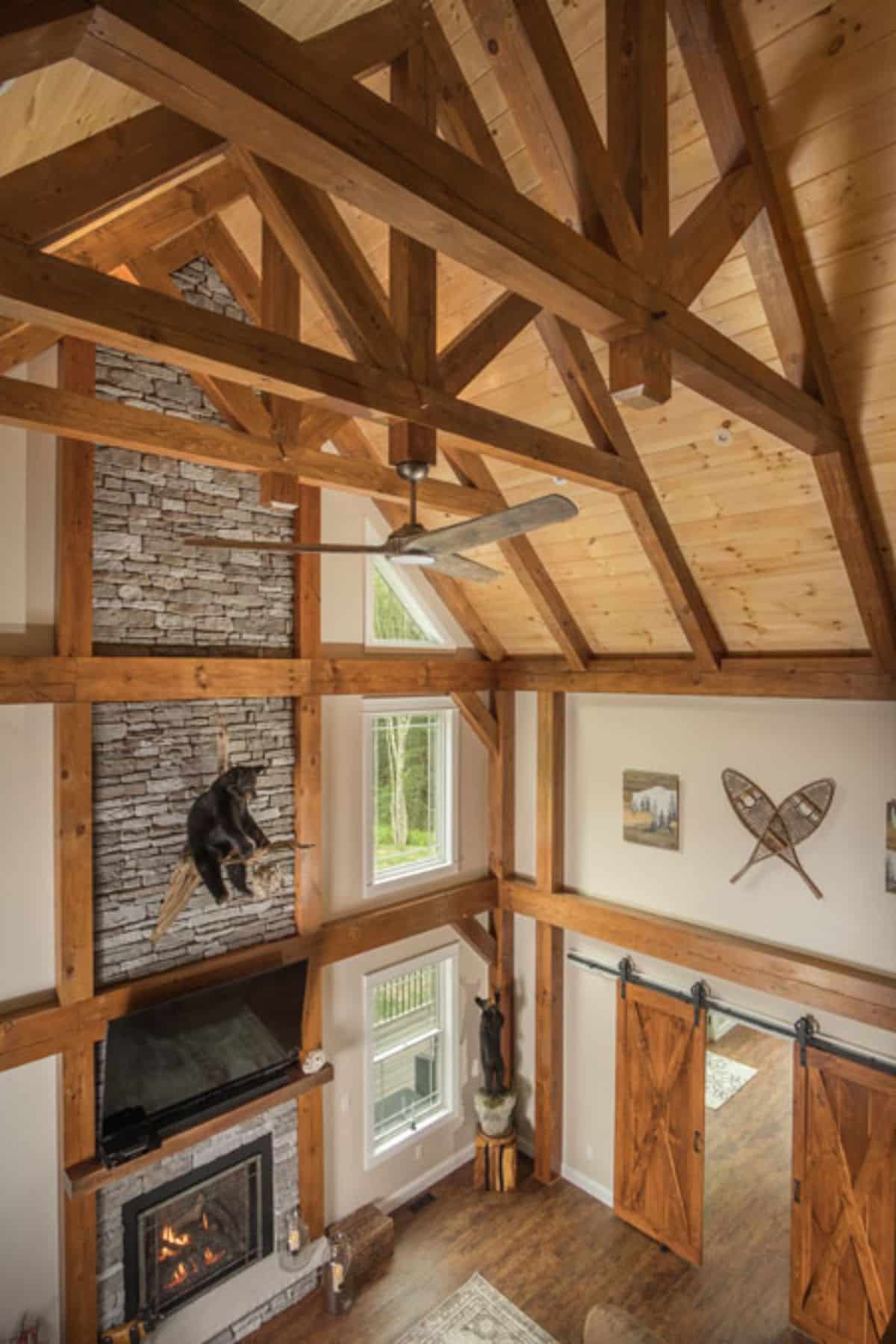 stone fireplace and chimney against wall between large picture windows