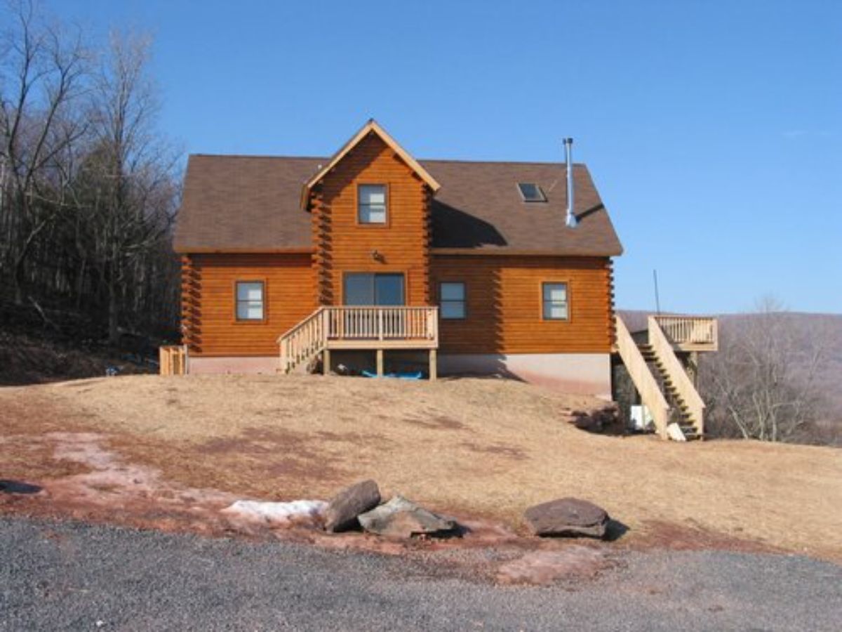 red brown siding on cabin on hill