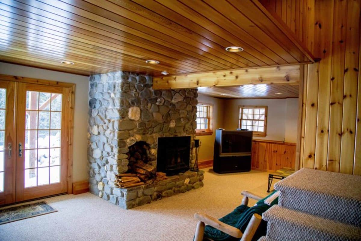 basement with fireplace in center and french doors on left
