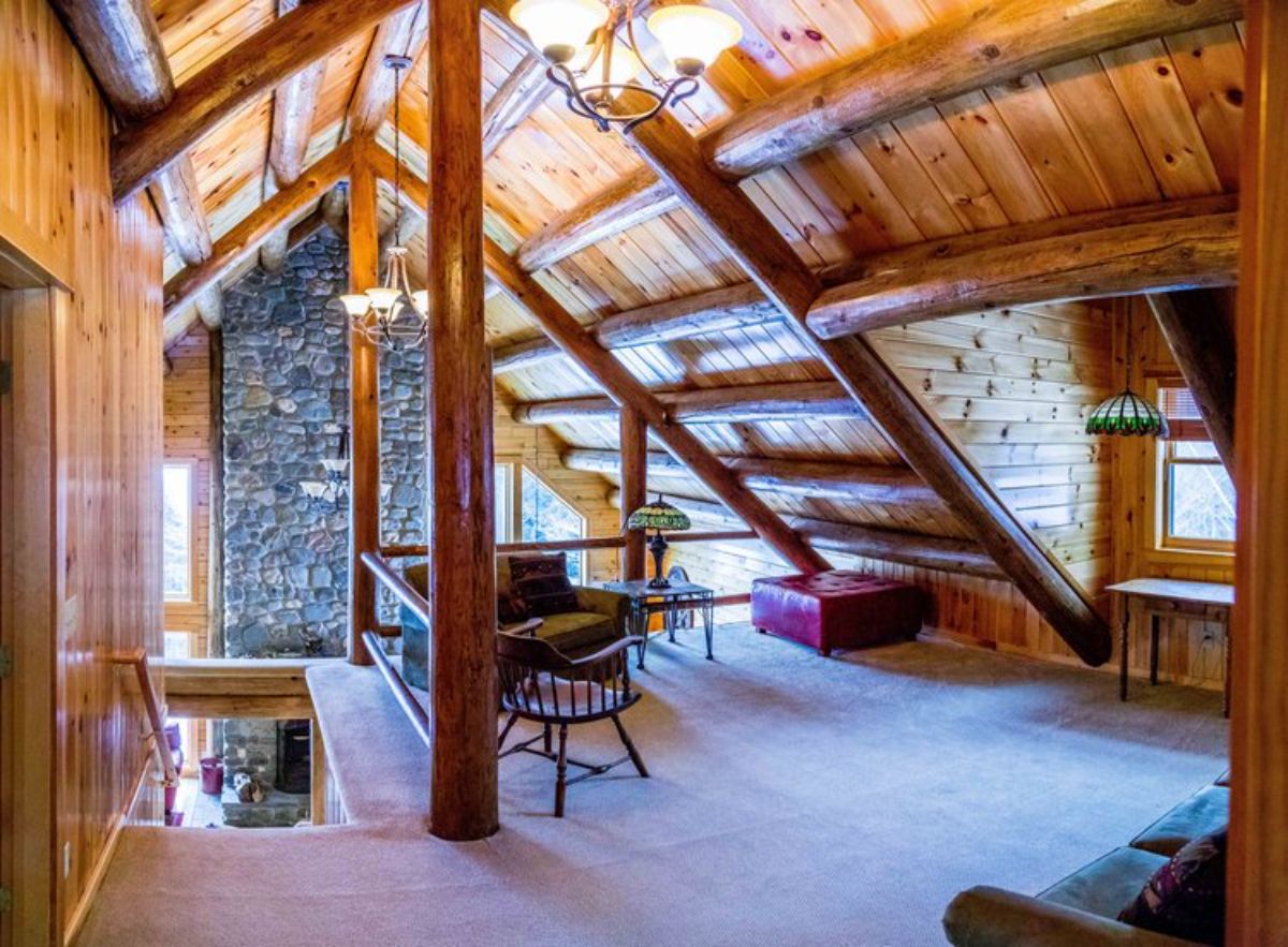 open loft landing with stairs on left and fireplace chimney in background