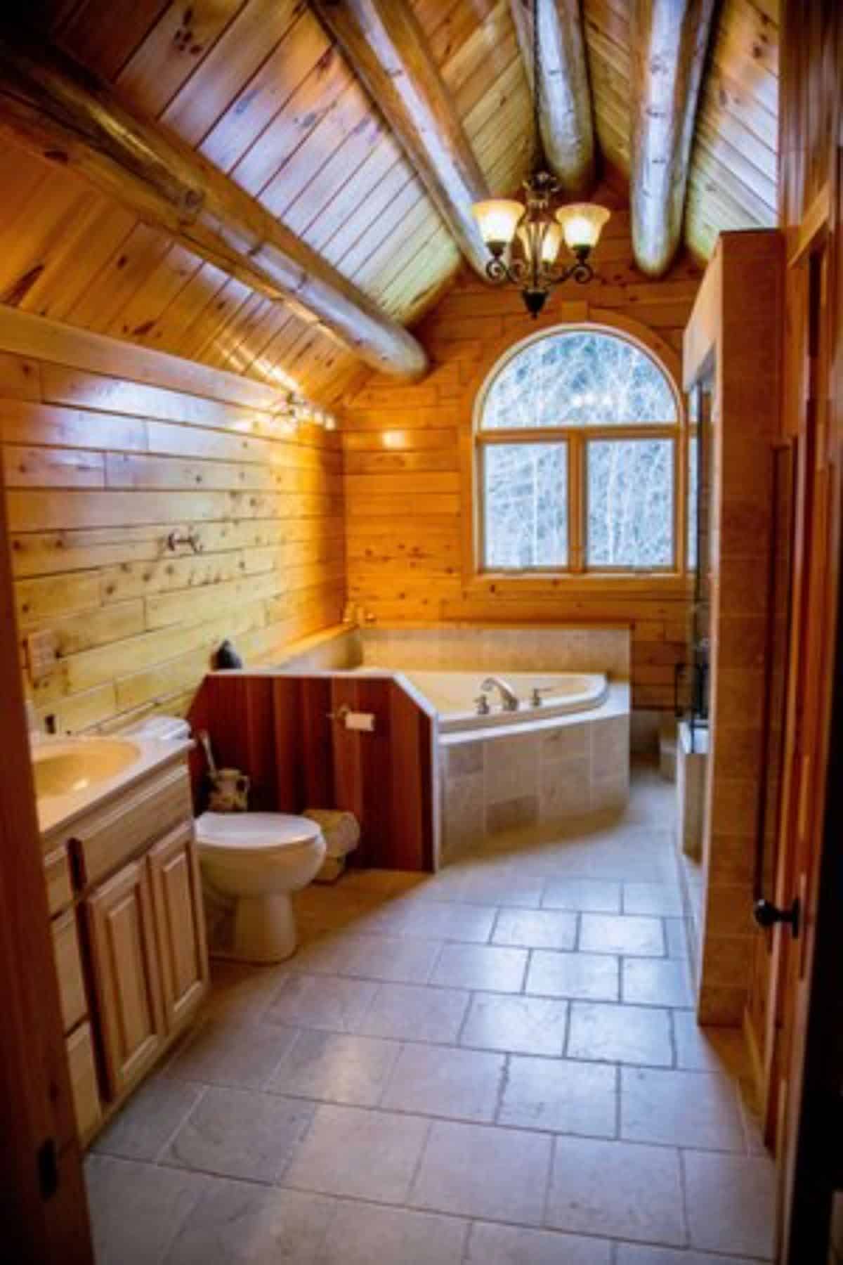 bathtub against wall by windows in bathroom