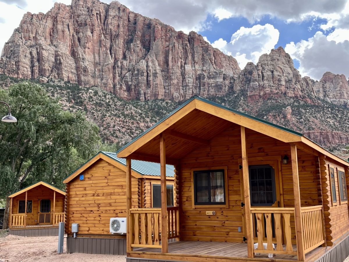 log tiny houses with mountains in background