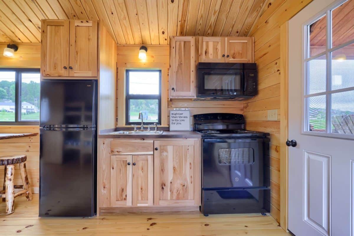 black appliances in kitchen with wood cabinets