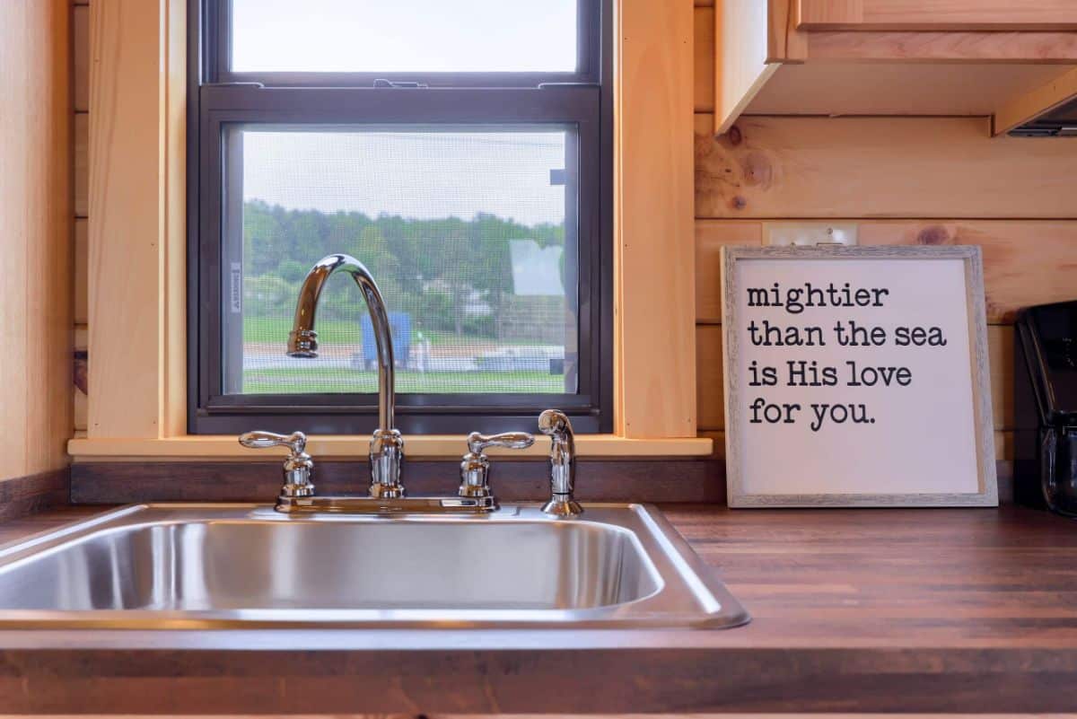 butcher block countertop around stainless steel sink under window