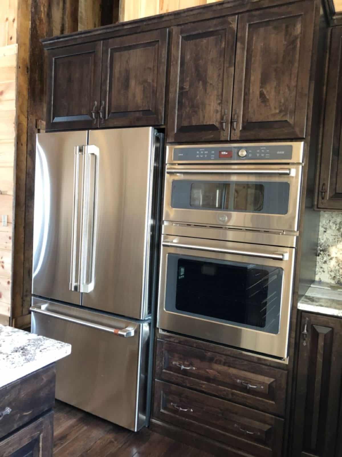 stainless steel appliances against wall with wood cabinets
