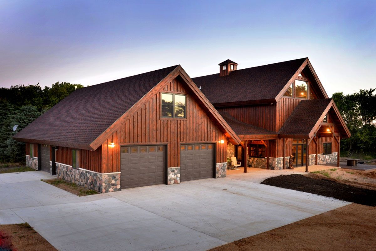 brown cabin with stone accents and 2 car attached garage